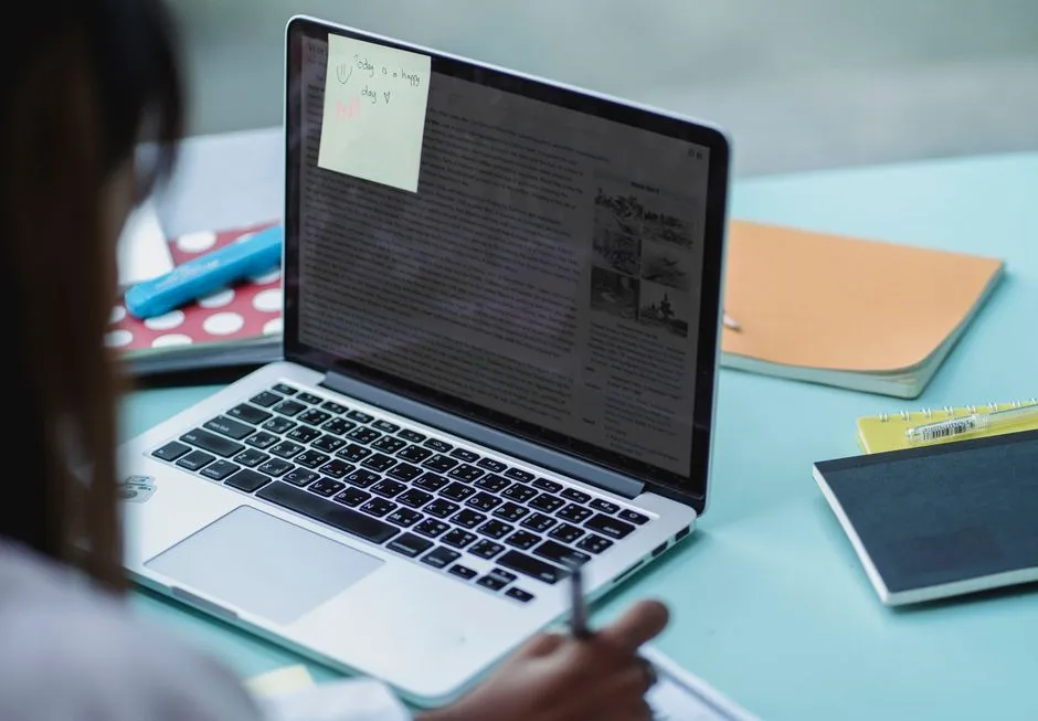 Adult learners studying together with a laptop and notes at a table