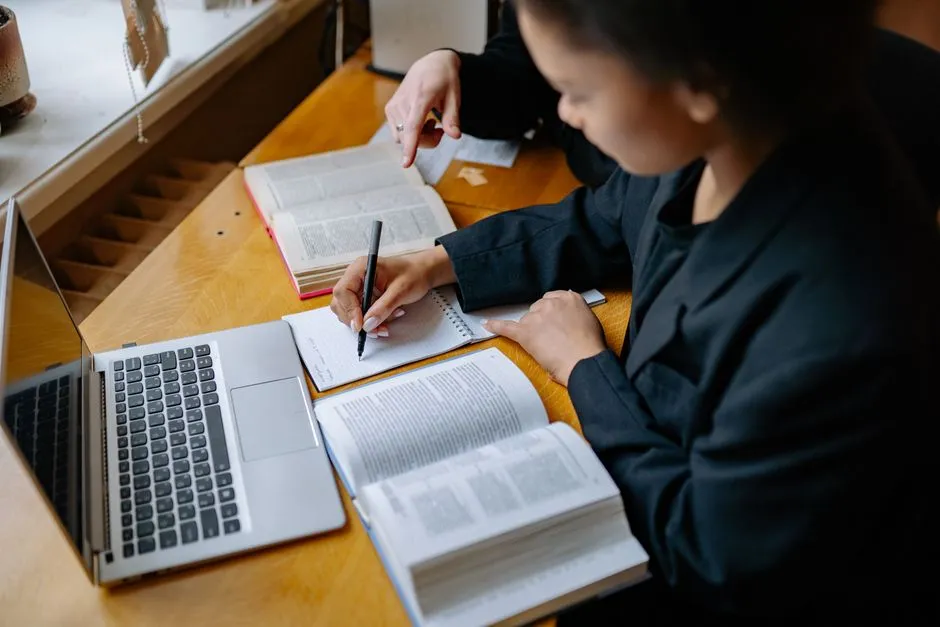 Person taking handwritten notes while studying for an exam